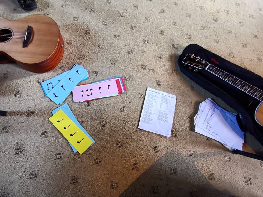 Guitars, rhythm cards and lesson sheets laid out for a music teaching session